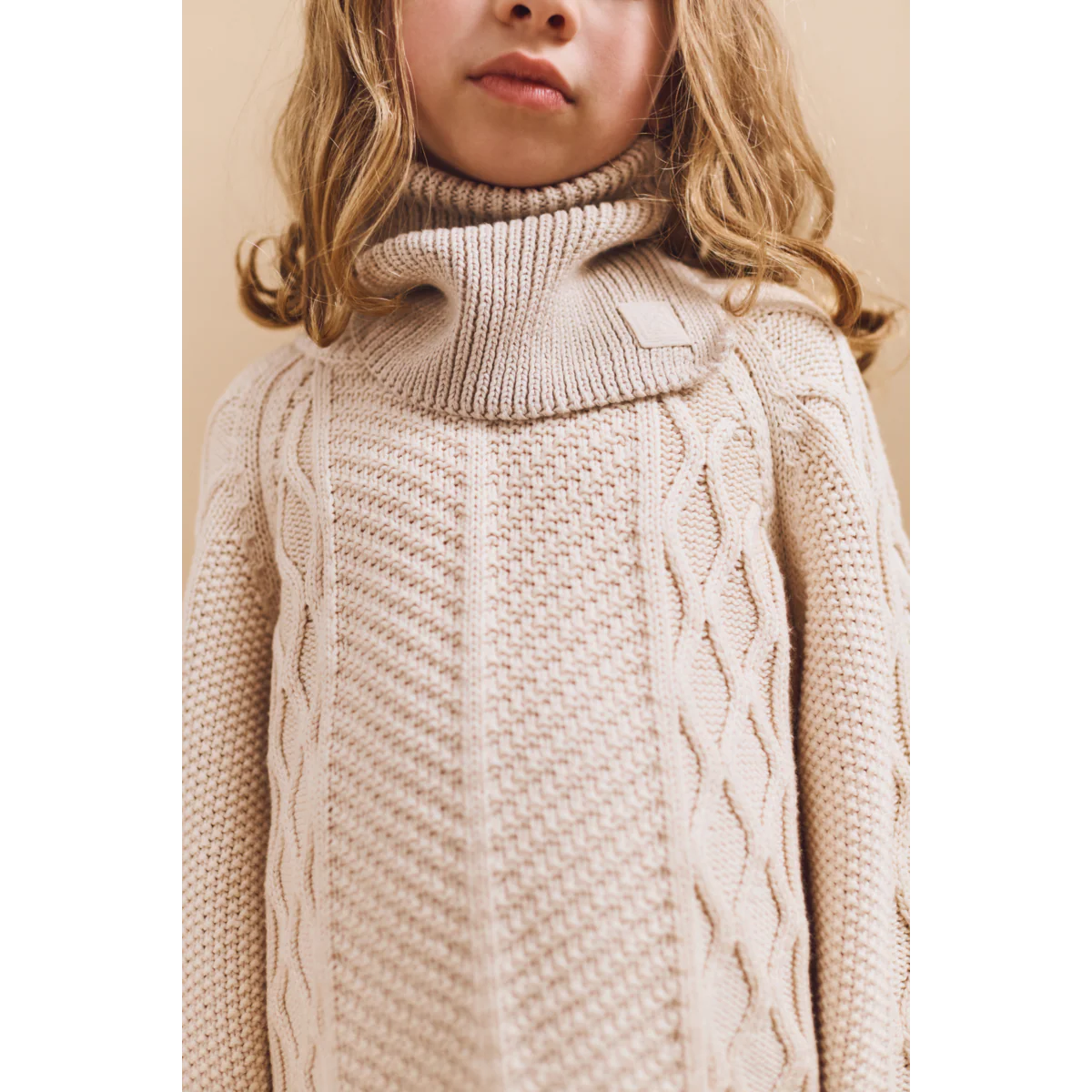 Der beige Halswärmer "Mathias" von Liewood ist eine gute Alternative zum Schal. Einfach unter der Jacke anziehen und keine nervigen Enden.