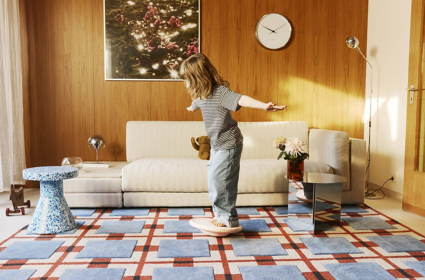 Kind balanciert auf Stapelstein® Balanceboard Spring Special "Petal" im Wohnzimmer - limitierte Edition, Bewegungsspielzeug zur Förderung von Gleichgewicht, Koordination und Motorik