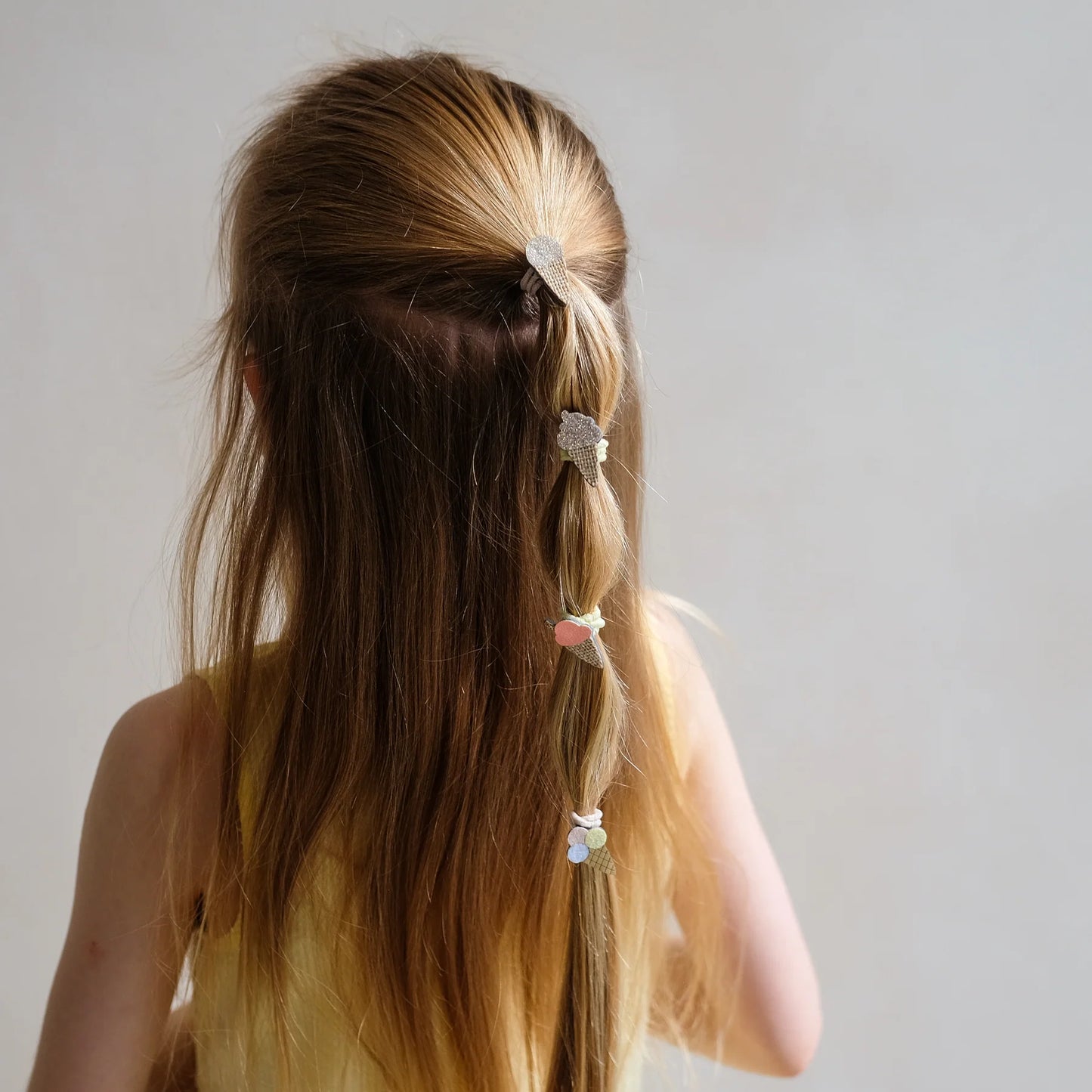 Mädchen mit langen Haaren trägt Mini Haargummis mit Eiscreme-Motiv von Mimi & Lula – stylisches Kinder-Haaraccessoire im 8er Set