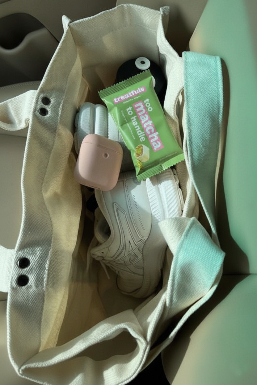 Treatfuls Matcha-Riegel „Too Matcha To Handle“ in einer Sporttasche neben Sneakern und Kopfhörern – leckerer und gesunder Snack für unterwegs und nach dem Sport