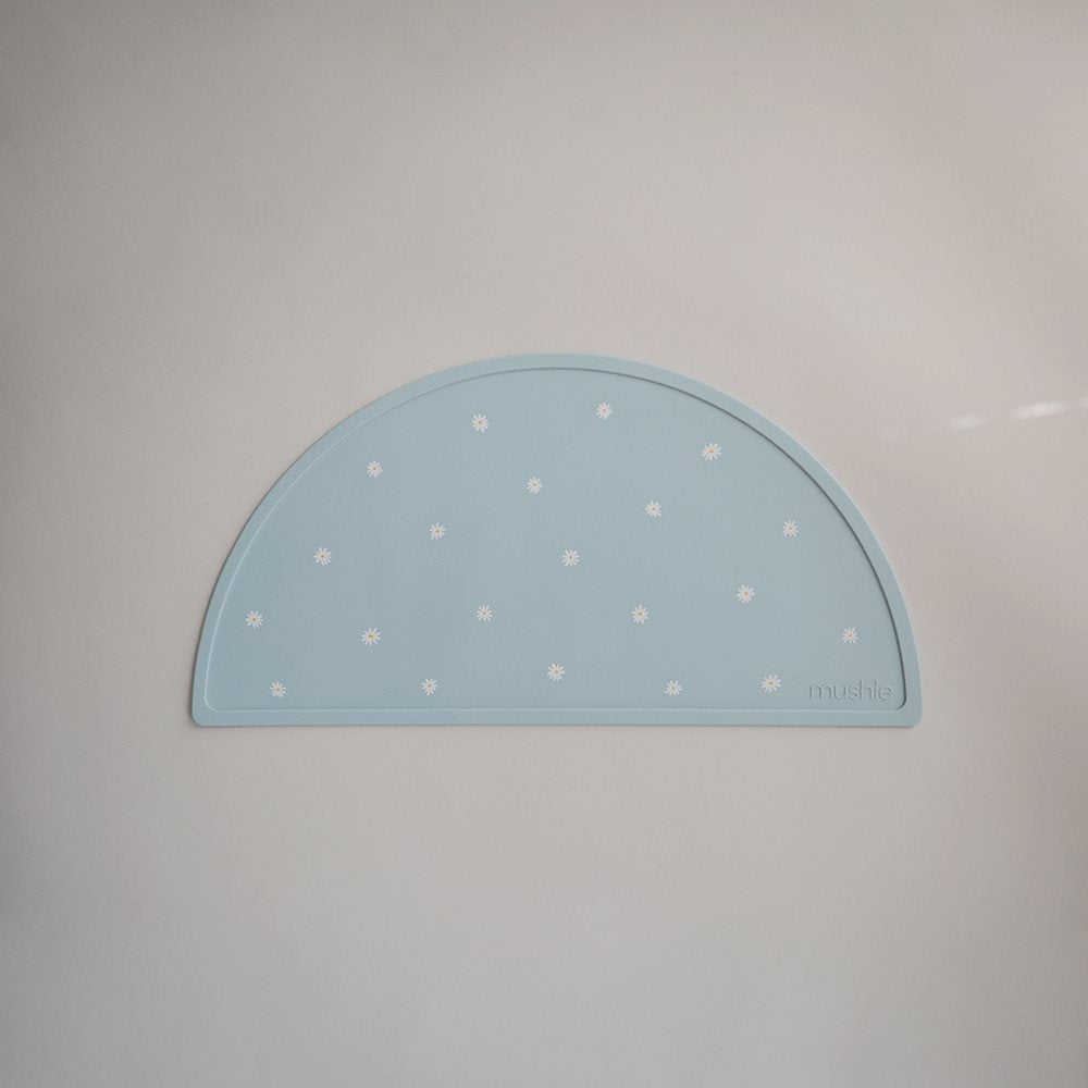 Light blue silicone mat with white daisies by Mushie