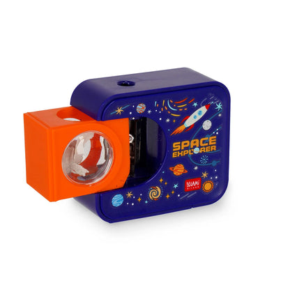 Elektrischer Anspitzer Space Explorer Weltraum-Motiv von Legami Schraegeansicht mit herausgezogenem orangem Auffangbehaelter und Sichtfenster mit Spaenen blaues Gehaeuse mit Rakete Planeten und Space Explorer Aufschrift auf weissem Hintergrund