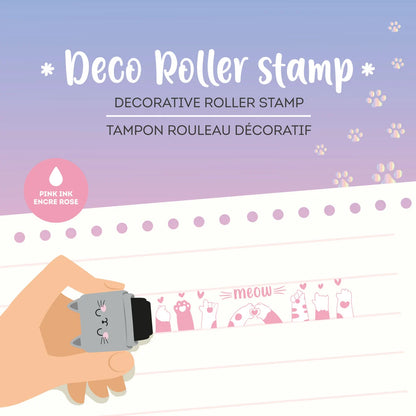 Katzen Deko-Rollstempel Deco Roller Stamp von Legami im Einsatz mit Hand die den Stempel haelt und Stempelmuster mit Katzen-Pfoten-Herz-Motiv auf lila-rosa Hintergrund als Geschenkidee zur Einschulung