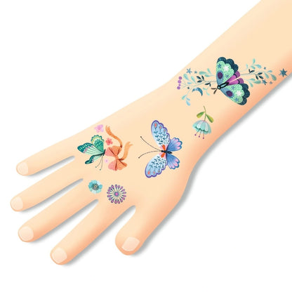 Anwendungsbeispiel der Djeco Tattoos Traumhafter Schmetterling auf einer Kinderhand mit bunten Schmetterlings- und Blumenmotiven bei Burgfrollein