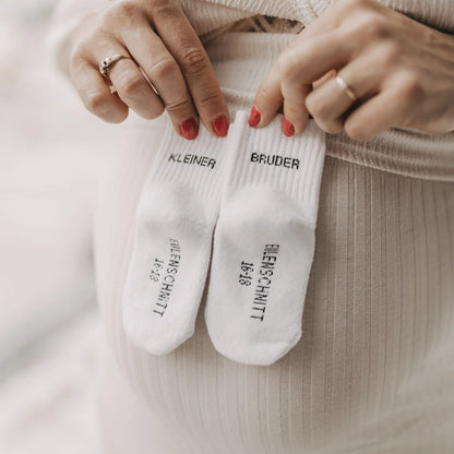 Detailansicht der Eulenschnitt Baby-Socken „Kleiner Bruder" in Weiß, Größe 16-18, mit Eulenschnitt Schriftzug auf der Sohle bei Burgfrollein