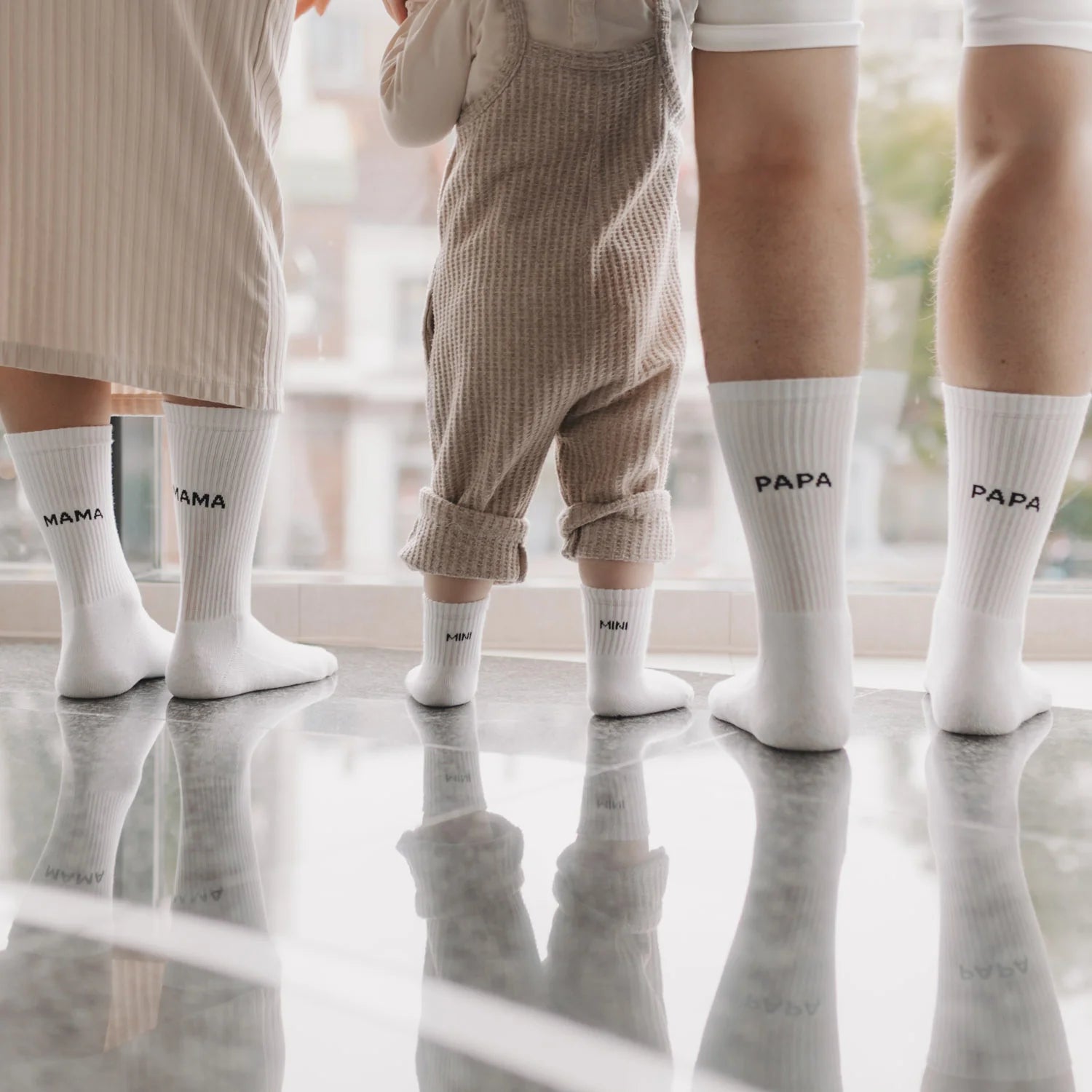 Eulenschnitt Socken-Familie in Weiß mit MAMA, PAPA und MINI Schriftzug – Lifestyle-Aufnahme mit Eltern und Kind bei Burgfrollein