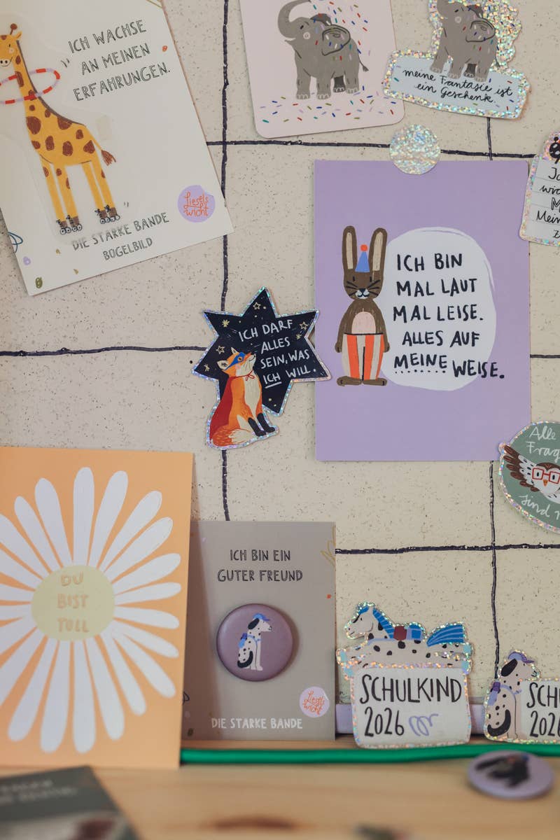 Verschiedene Glitzersticker und Postkarten von Liesel's Wicht mit Giraffe, Elefant und Schulkind-Motiven – vielfältige Geschenkideen für jeden Anlass
