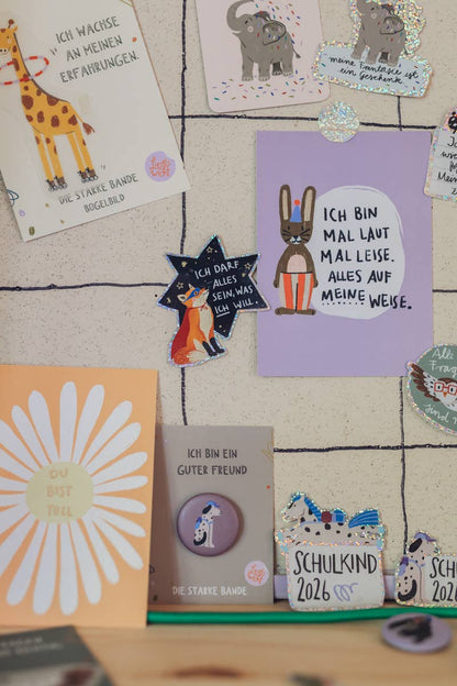 Verschiedene Glitzersticker und Postkarten von Liesel's Wicht mit Giraffe, Elefant und Schulkind-Motiven – vielfältige Geschenkideen für jeden Anlass