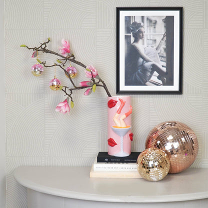 Discokugel „für gute Laune“ von House Vitamin (6 cm) als Deko an einem Magnolienzweig, daneben größere rosé- und goldfarbene Discokugeln auf einem Beistelltisch – stylischer Hingucker für die Wohnung und Geschenkidee