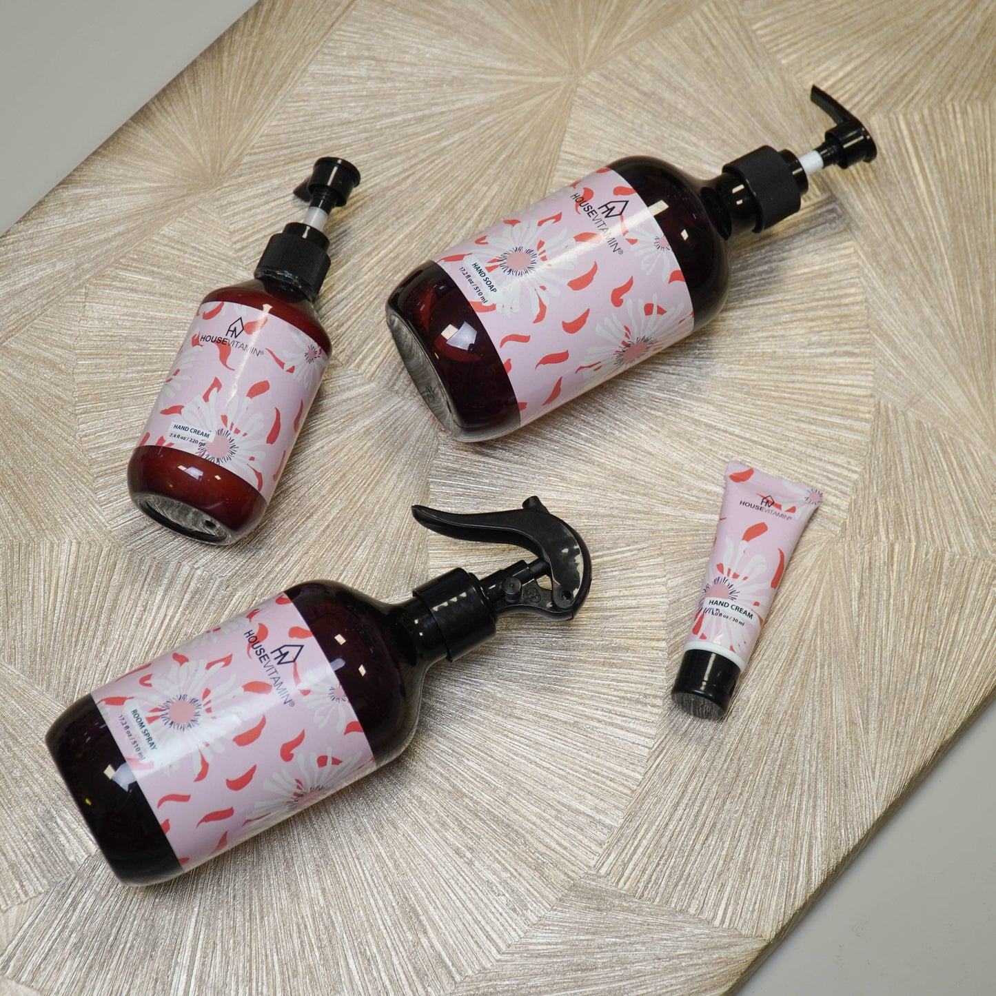 Kleine Tube Handcreme „Pfingstrosenblüte" von House Vitamin, 30 ml, im Größenvergleich neben größeren Pumpflaschen der Pflegeserie auf hellem Holzuntergrund – florales Design als pflegende Wellness- und Geschenkidee