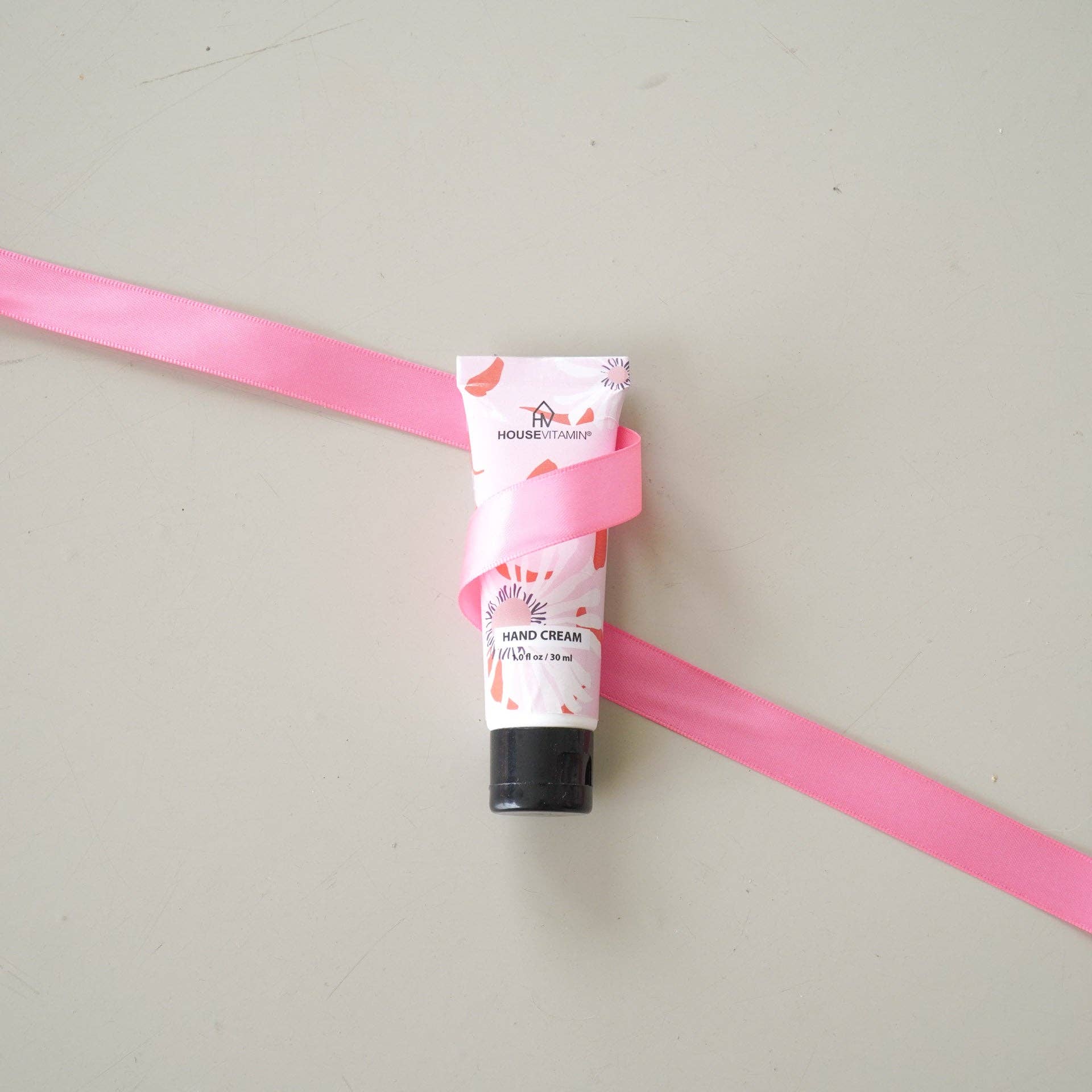 Kleine Tube Handcreme „Pfingstrosenblüte" von House Vitamin, 30 ml, stehend umwickelt mit rosa Satinband auf hellem Untergrund – florale Handpflege als liebevoll verpackte Geschenkidee