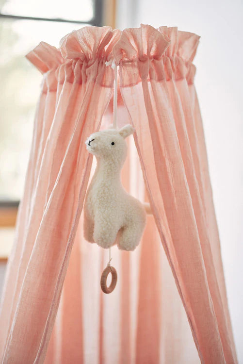 Jollein Lama-Spieluhr hängt am rosa Betthimmel im Babyzimmer – schöne Geschenkidee zur Geburt