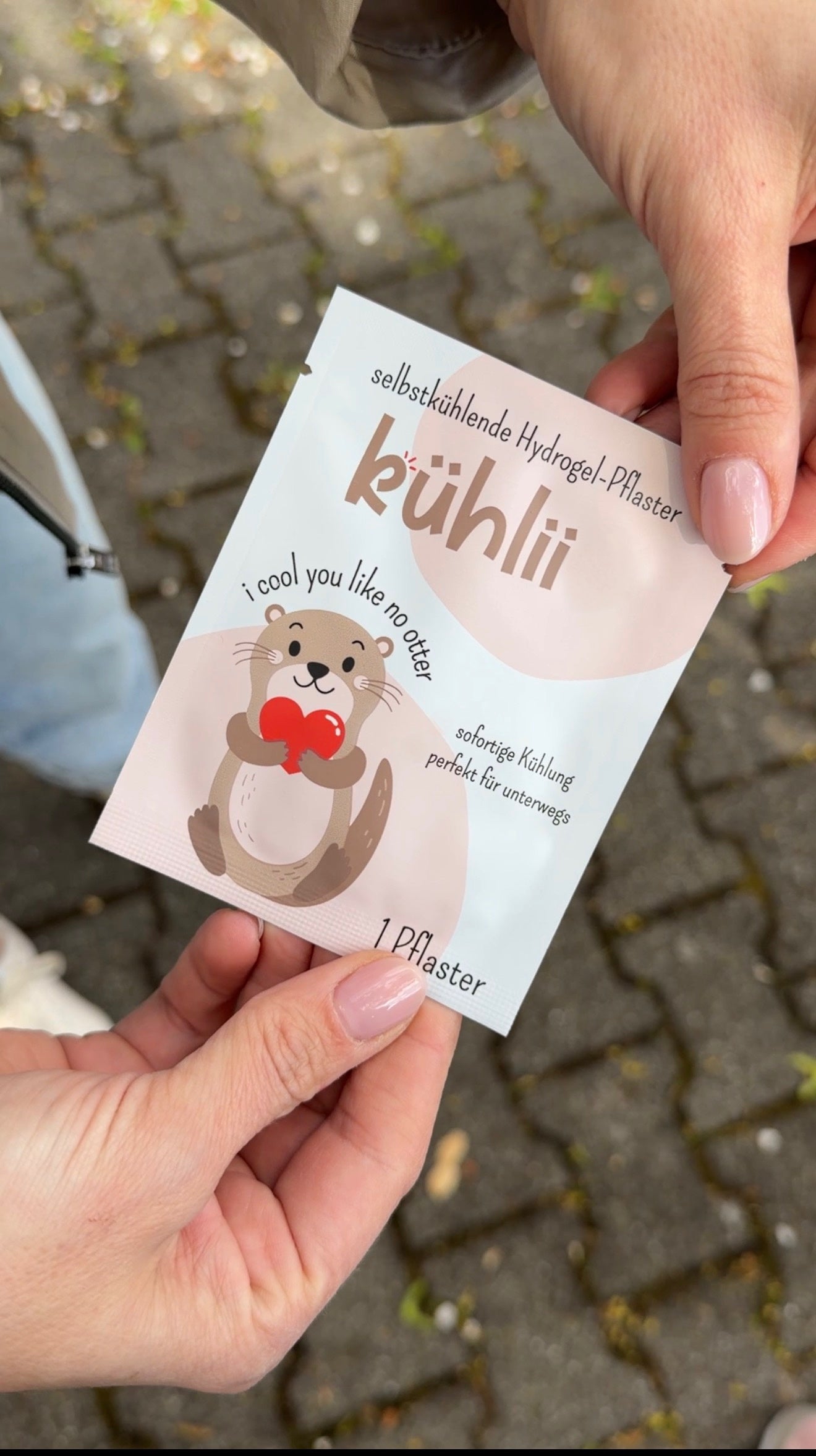 Kühlii Hydrogel-Pflaster im Otterdesign wird im Freien überreicht – selbstkühlend gegen Beulen für unterwegs