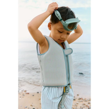 Kind am Strand mit Liewood Schwimmweste in Mint gestreift und passender Schwimmbrille im sommerlichen Lifestyle-Look bei Burgfrollein