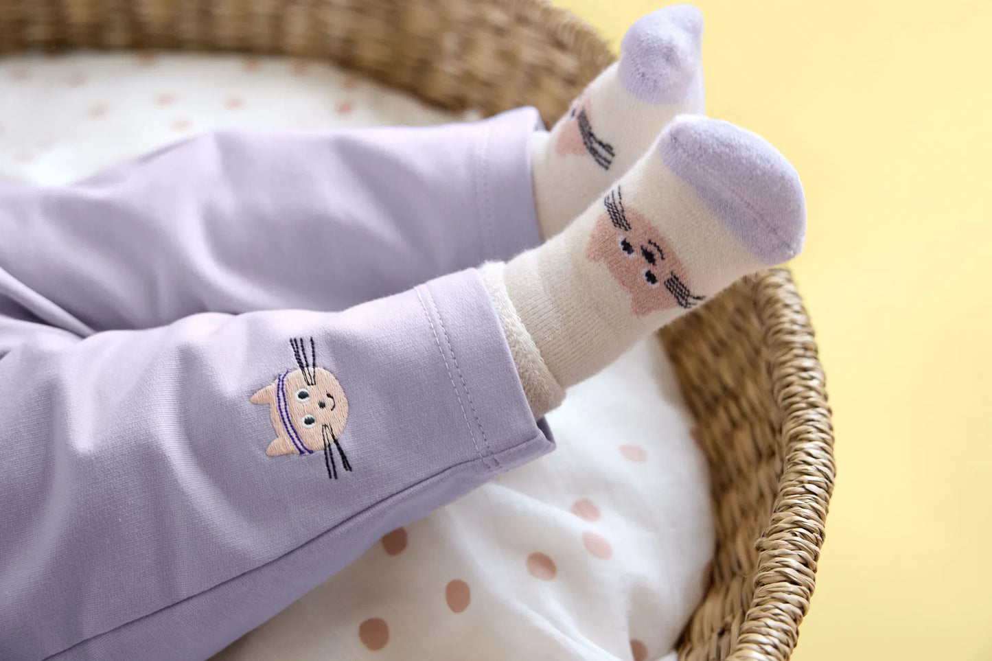 Babyfüße in lila Babysocken mit Katzen-Motiv aus dem 3er Set „Katze" von Lässig – weiche Terry-Erstlingssöckchen im Stubenwagen