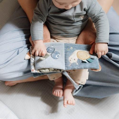 Baby spielt mit aufgeklapptem Little Dutch Buggybuch Forest Friends in Blau mit Schnecke und Blaubeeren – Babybuch für Kinderwagen und Maxi-Cosi bei Burgfrollein