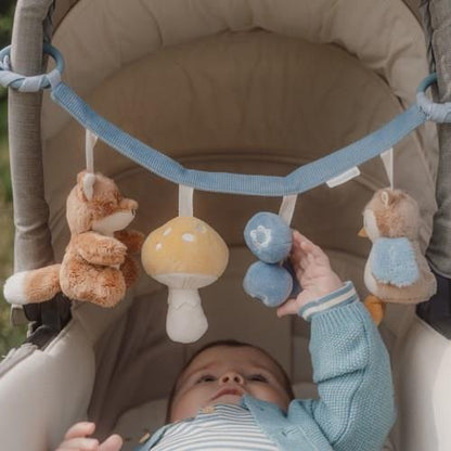 Baby greift nach den Anhängern der Little Dutch Kinderwagenkette Forest Friends in Blau mit Bär, Pilz, Vogel und Eichhörnchen – Babyspielzeug für Kinderwagen und Maxi-Cosi bei Burgfrollein