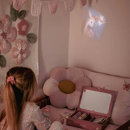 Mädchen projiziert mit der Little Dutch Geschichten-Taschenlampe aus der Fairy Garden Kollektion in Rosa das Bild eines Rehs an die Wand im Kinderzimmer, daneben die geöffnete rosa Geschenkbox