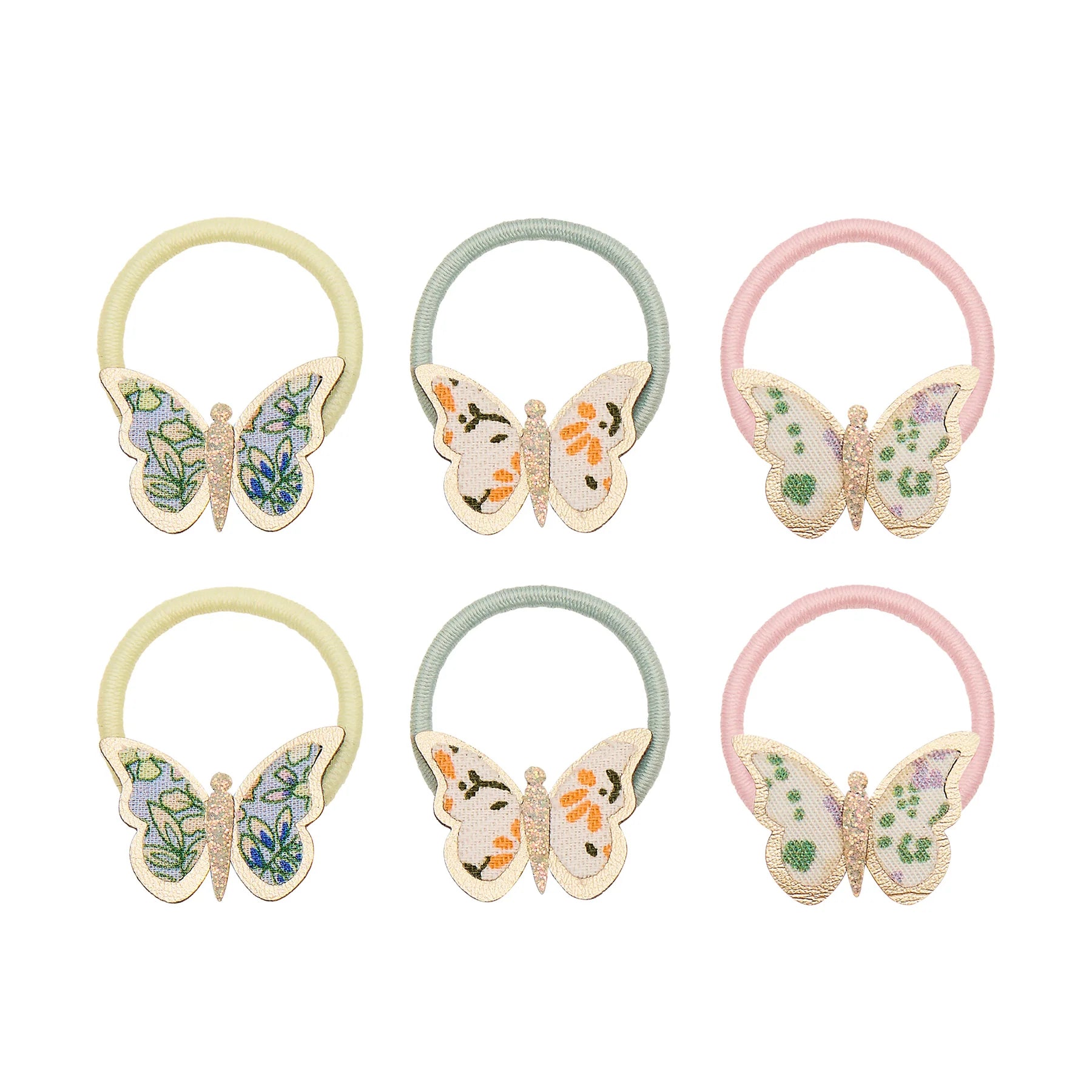 Haargummis mit Schmetterling-Motiv von Mimi & Lula, 6er Set in Pastelltönen Gelb, Mint und Rosa mit floral gemusterten Stoff-Schmetterlingen, aufgereiht und freigestellt vor weißem Hintergrund – frühlingshafter Haarschmuck für Kinder und liebevolle Geschenkidee