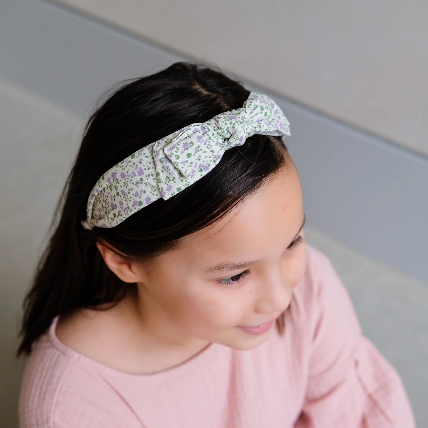 Mädchen trägt Haarreif Edie Alice mit lila Blumen-Motiv und Schleife von Mimi & Lula – Detailansicht des stylischen Kinder-Haaraccessoires im Frühlings-Look