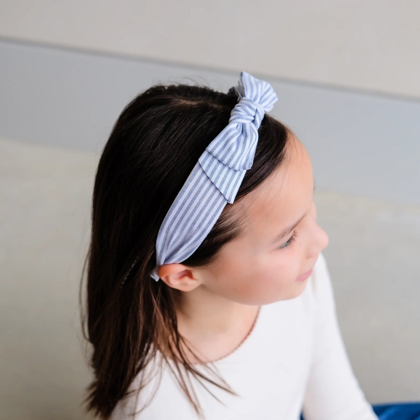 Mädchen trägt Haarreif Stripe Bow Alice mit blau-weißen Streifen und Schleife von Mimi & Lula – stylisches Kinder-Haaraccessoire im maritimen Look