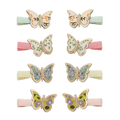 Kleine Schmetterling-Haarspangen von Mimi & Lula, 8er-Set mit floralen Schmetterlings-Motiven und Glitzer-Rand auf Stoffspangen in Mint, Rosa, Creme und Pastelltönen, aufgereiht und freigestellt vor weißem Hintergrund – kinderfreundlicher Haarschmuck und liebevolle Geschenkidee