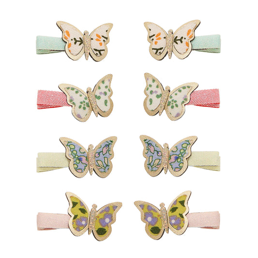 Kleine Schmetterling-Haarspangen von Mimi & Lula, 8er-Set mit floralen Schmetterlings-Motiven und Glitzer-Rand auf Stoffspangen in Mint, Rosa, Creme und Pastelltönen, aufgereiht und freigestellt vor weißem Hintergrund – kinderfreundlicher Haarschmuck und liebevolle Geschenkidee
