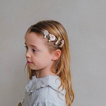 Mädchen trägt kleine Haarspangen mit Meerjungfrauen-, Fisch-, Seestern- und Muschel-Motiv von Mimi & Lula – stylisches Kinder-Haaraccessoire im 8er Set