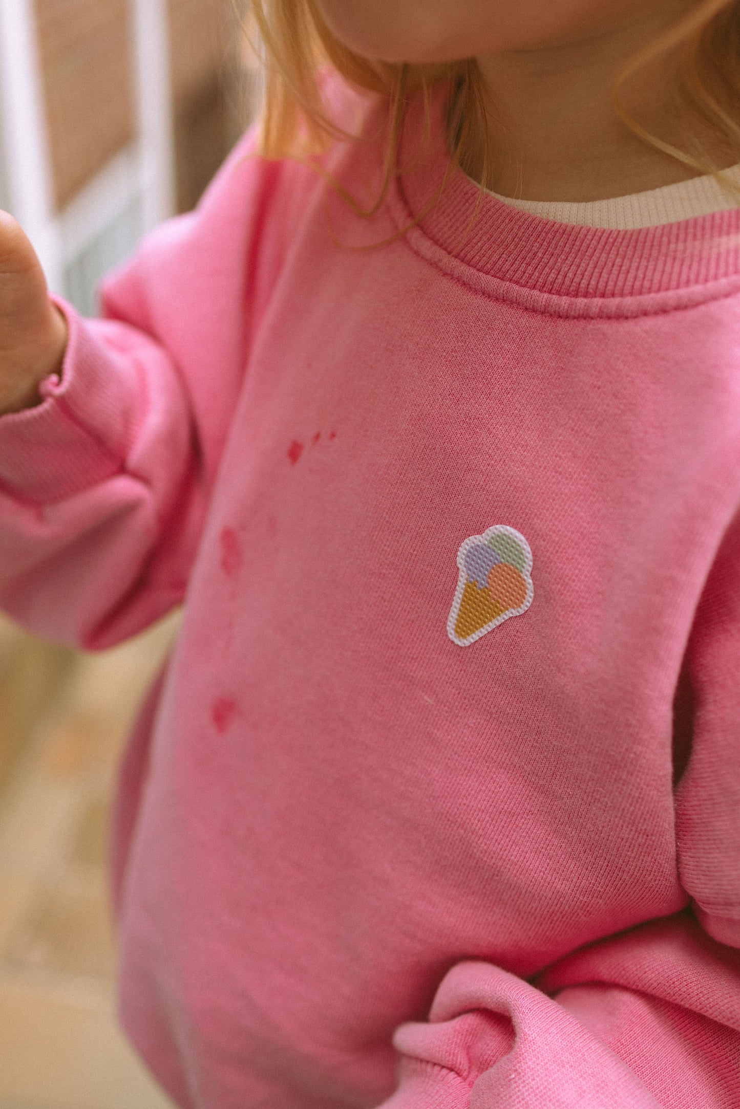 Mädchen trägt Pieksmichnicht Anti-Mücken-Sticker Cool Kids Edition mit Eis-Motiv auf der Kleidung – pflanzlicher Mückenschutz