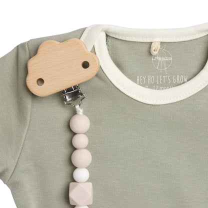 Rosa Schnullerkette „Little Universe“ von Lässig in Anwendung – Wolken-Holzclip am Babybody befestigt