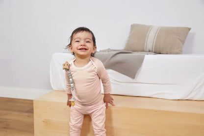 Lachendes Baby trägt mintgrüne Schnullerkette Little Universe von Lässig am Strampler