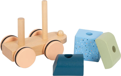 Detailansicht des Lokomotive-Fahrgestells mit zwei Stapelstäben des blauen Holzzugs „Arctic“ von Small Foot sowie daneben liegenden gemusterten Bauelementen in Blau und Grün – nachhaltiges Holzspielzeug zur Förderung der Feinmotorik und Kreativität