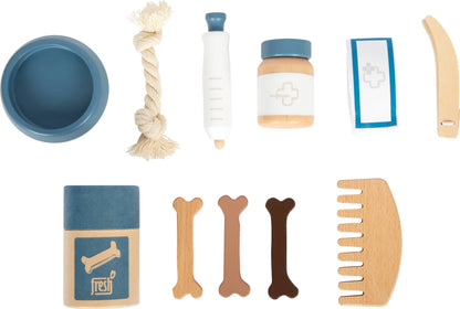 Übersicht des Pflegezubehörs aus dem Set „Hund mit Tasche und Pflegeset“ von Small Foot mit blauem Futternapf, Knotenseil, Spritze, Medikamentendose, Pflaster, Feile, Leckerli-Dose, drei Holzknochen und Kamm – nachhaltiges Rollenspielzeug zur Förderung der Fürsorge und Kreativität