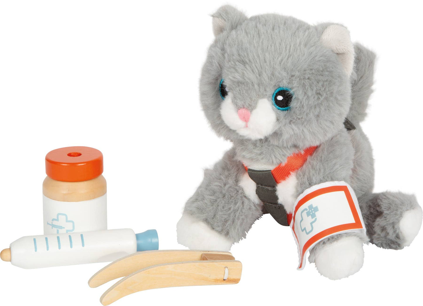 Graue Plüsch-Katze sitzend mit angelegtem rotem Geschirr und Pflaster am Pfötchen neben Spritze, Medikamentendose und Feile aus dem Set „Katze mit Tasche und Pflegeset“ von Small Foot – nachhaltiges Rollenspielzeug zur Förderung der Fürsorge und Kreativität