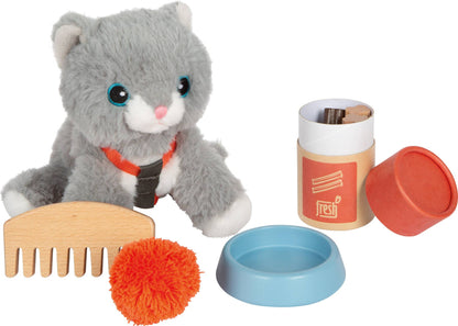 Graue Plüsch-Katze mit angelegtem rotem Geschirr neben ausgewähltem Zubehör aus dem Set „Katze mit Tasche und Pflegeset“ von Small Foot mit Holzkamm, oranger Spielmaus, hellblauem Futternapf und Leckerli-Dose – nachhaltiges Rollenspielzeug zur Förderung der Fürsorge und Kreativität
