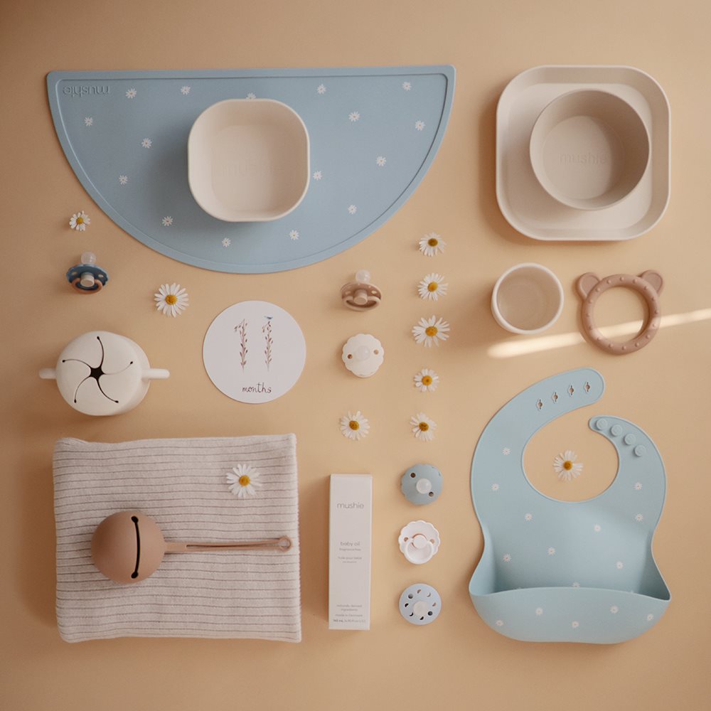 Lichtblauwe siliconen placemat met witte madeliefjes van Mushie