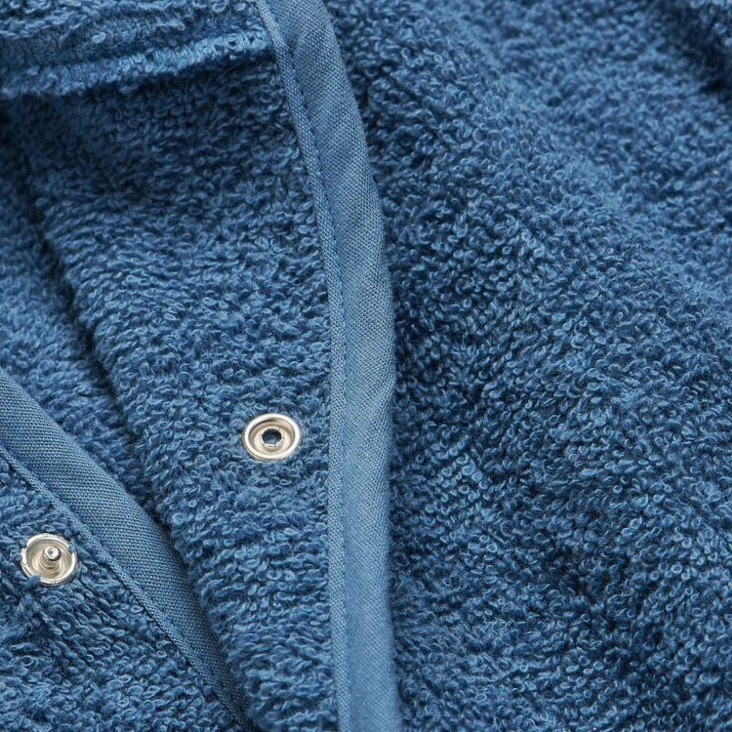 Nahaufnahme des weichen Frottee-Materials und der Druckknöpfe am Jollein Bademantel dunkelblau