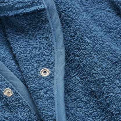 Nahaufnahme des weichen Frottee-Materials und der Druckknöpfe am Jollein Bademantel dunkelblau