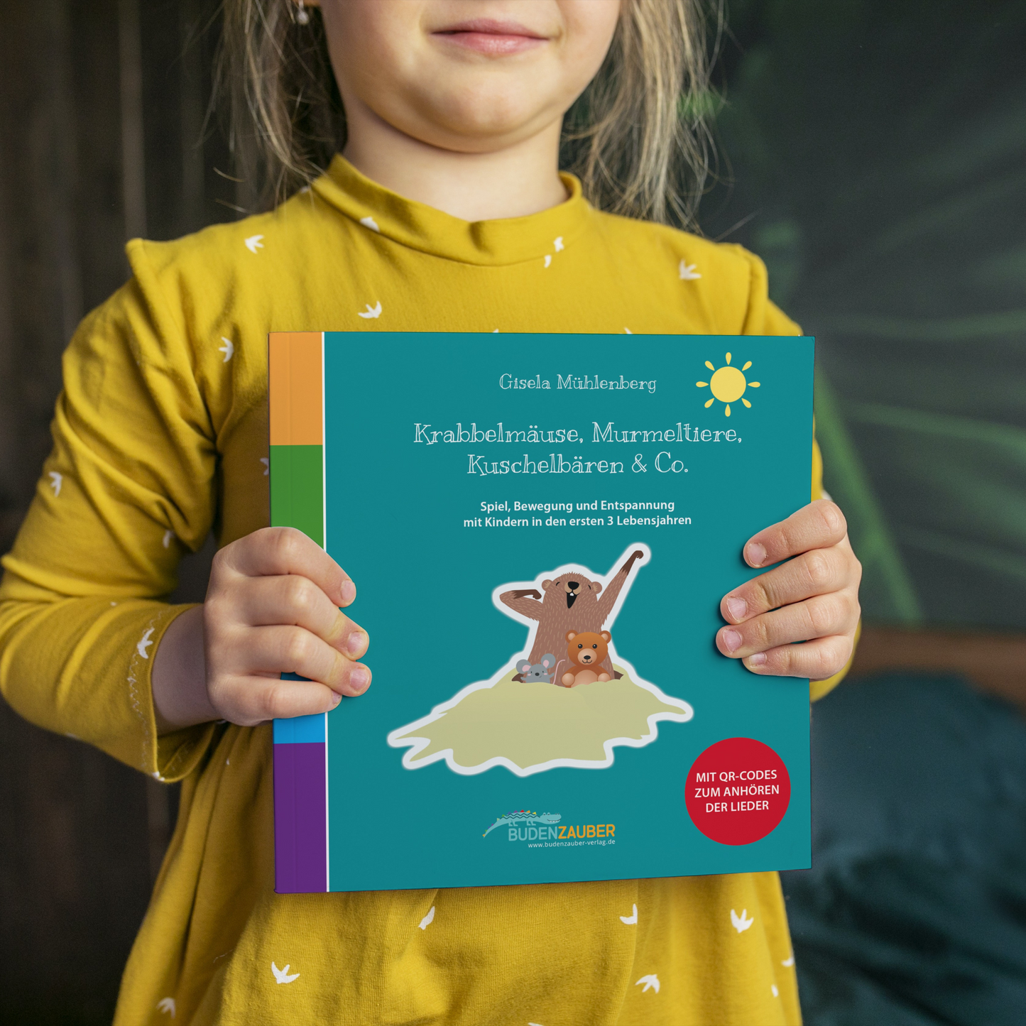 Kind hält das Buch Krabbelmäuse, Murmeltiere, Kuschelbären & Co. von Gisela Mühlenberg in die Kamera – liebevolles Spiel- und Liederbuch für Babys und Kleinkinder, Geschenkidee zur Geburt und Taufe von Burgfrollein