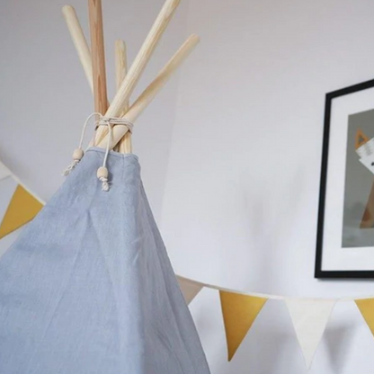 Kinderzimmer-Dekoration mit Wimpelkette in Gelb und Creme neben blaugrauem Kinder-Tipi